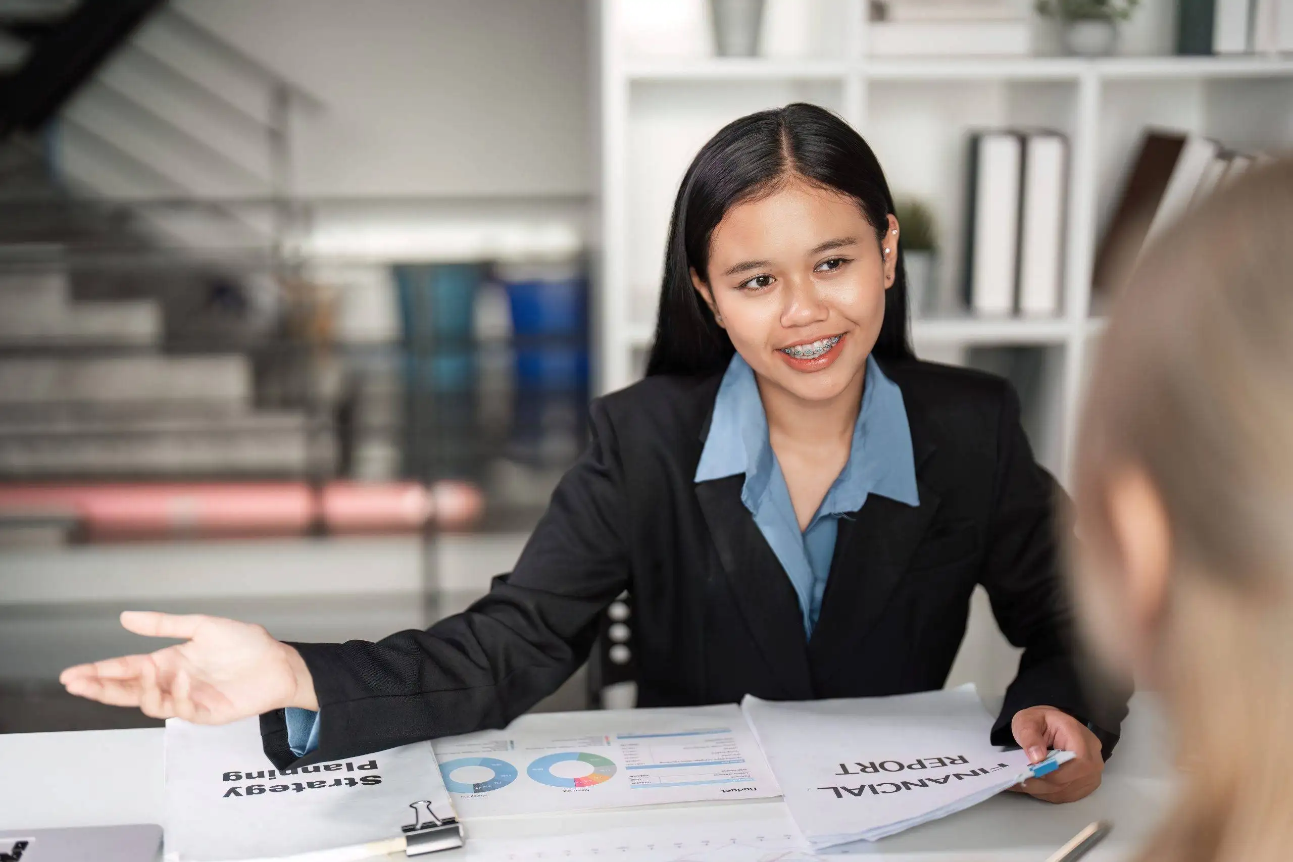 Pengusaha Indonesia sedang memeriksa laporan cashflow bisnis di meja kantor, didampingi tim UCC Global Indonesia yang berdiskusi solusi penagihan piutang.